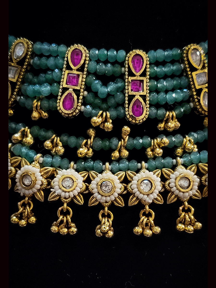 Multiple aqua strings set with ruby and kundan and white tukdies with ghunghru hangings