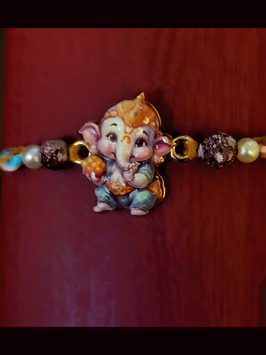 Coloured enamel bal ganpati rakhi with coloured cotton thread