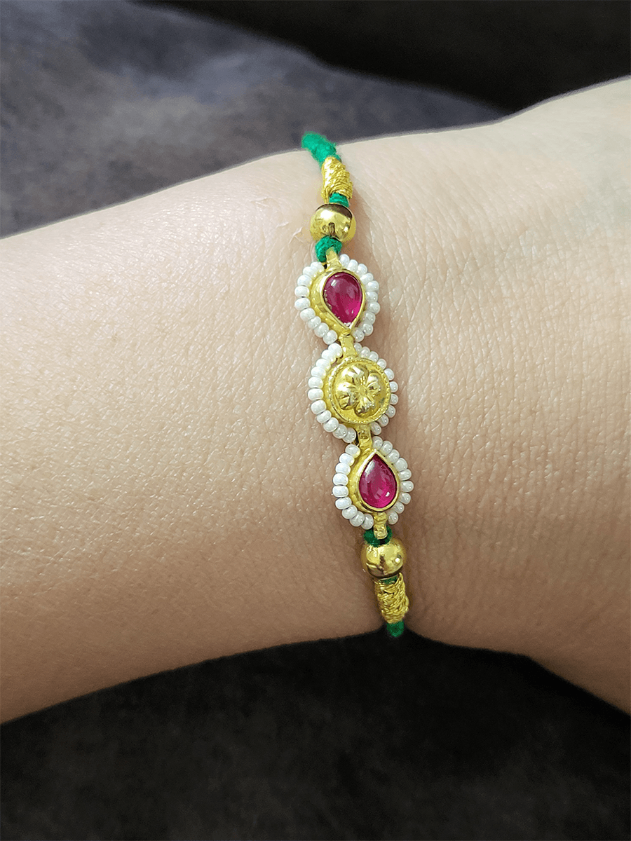 Two ruby leaf stones with pirohi work and antique tukdi rakhi in green thread - Odara Jewellery