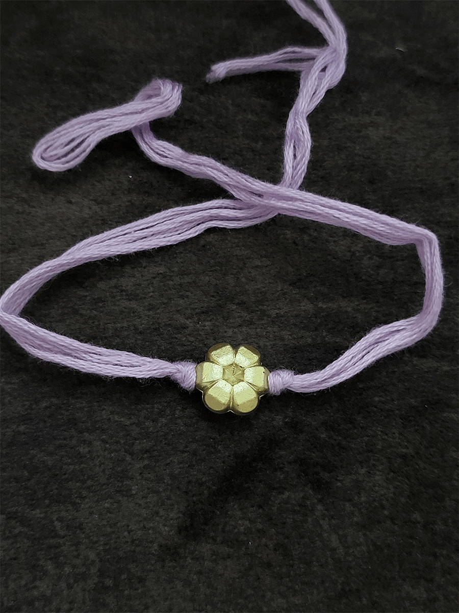 Small gold flower bead in thread rakhi - Odara Jewellery